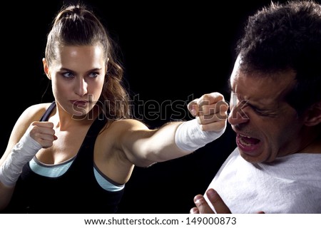 young fit woman fighting a man. battle of the sexes.