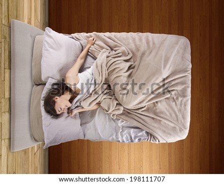 top view of young female in bed unable to sleep