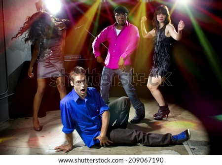 Caucasian man falls but confidently plays cool in a dance club