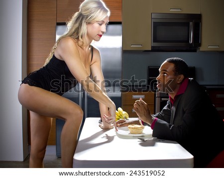 sexy caucasian female distracting african american boyfriend from dinner