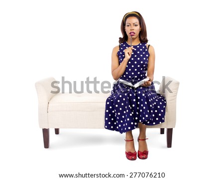 Vintage style black female author writing and sitting on a chaise lounge isolated on a white background.