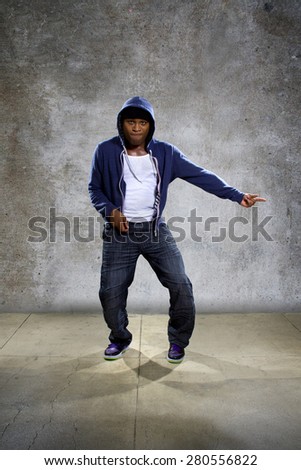 black man wearing a blue hoodie pointing at something