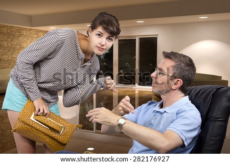 Single father waiting for daughter to come home late at night past curfew.  The dad is sitting on a chair.  This image depicts fatherhood or being a single parent.