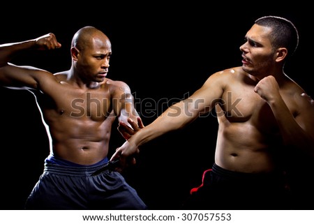 Martial arts instructor demonstrating self defense against a knife attack. He is performing close quarter combat counter attacks against a weapon.