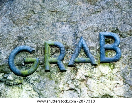 Metal letters on stone making the word grab, background
