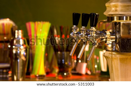 Some beer taps in a cocktail bar, focus on the first tap, background