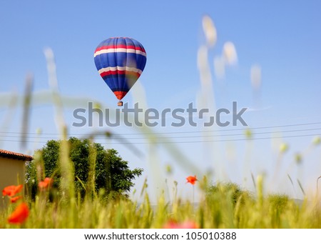 Hot air balloon landing in a field in Vic, Spain.