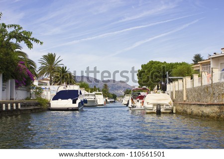 Luxurious yachts in a canal in Empuriabrava, way of life with luxury condos.