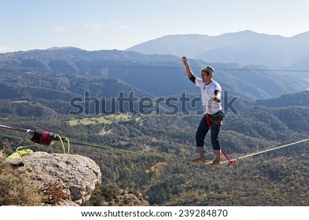 TAVERTET - NOVEMBER 16: Man doing highline in Tavertet, Spain on November 16, 2014. Highline is a balance sport that consists walking through a rope clamped between two points and great height below.