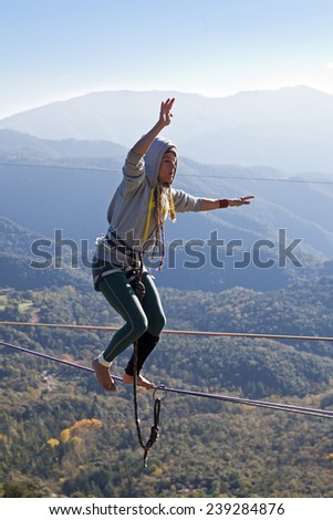 TAVERTET - NOVEMBER 16: Woman doing highline in Tavertet, Spain on November 16, 2014. Highline is a balance sport that consists walking through a rope clamped between two points and great height.