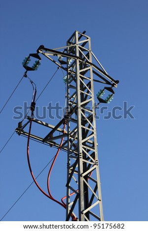 It is an electric tower and a blue sky in the background. It is a medium voltage tower and there is a tension of 25000 V.