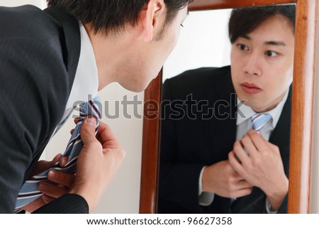 The businessman is looks at a mirror.