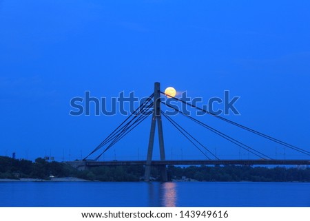The full moon rose over the bridge