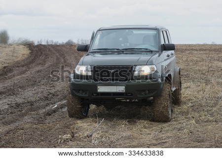 LENINGRAD REGION, RUSSIA - APRIL 05, 2015: UAZ-Patriot is on a dim field road on a cloudy spring day