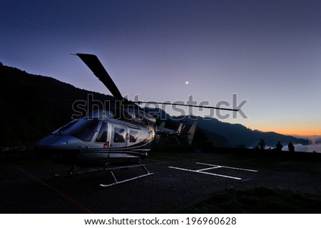 A helicopter on the landing pad at dusk.