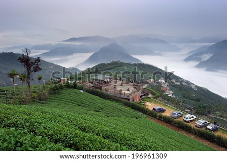 Homes on a hillside over looking foggy mountains.