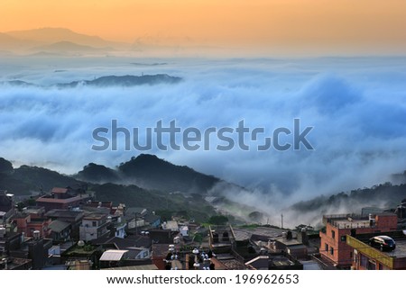A town above the clouds and fog of the mountains.