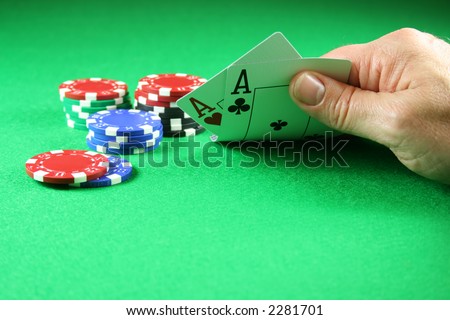 A player showing a pair of aces with poker chips next to them