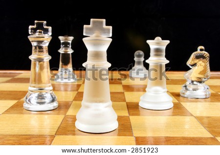 End Game - Glass Chess Pieces on a wooden chessboard