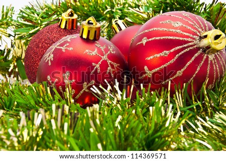 red New Year\'s spheres are photographed against green tinsel