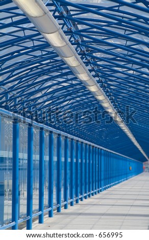 Long covered walkway at airport. Focus in foreground.