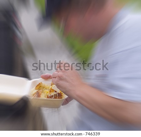 Zoom in on man eating fast food (jacket potato)