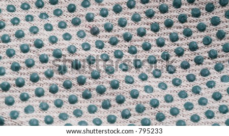 Macro of white cotton cloth with green blue blobs. Detail of extra-grip work glove.