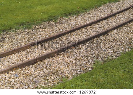 Rusty rails of miniature railway track in a British public park.