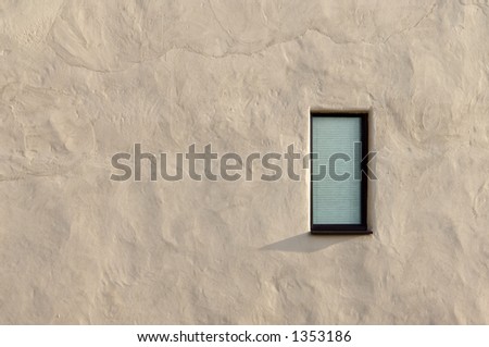 single bathroom window with frosted glass and blind in rough white plaster wall.
