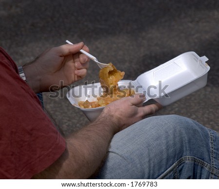 Man eating takeaway meal of jacket potato and beans.