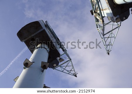 Low-angle view of two old rusty dock cranes against blue sky. Salford, Manchester, England