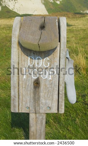 Wooden container for dog mess with grass background