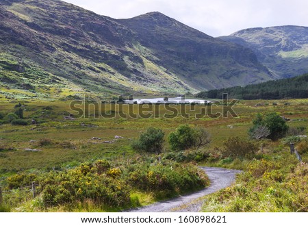 The remote and peaceful Black Valley, close to the Gap of Dunloe near Killarney, County Kerry, accessible by a single track road. Typical Irish country scene of green grass and rugged blue mountains.