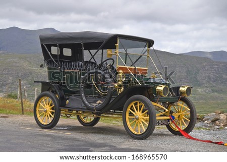 CO. KERRY, IRELAND - JULY 11 2006: Elegant vintage car from the Edwardian era with tow rope attached, parked at the roadside amid mountain scenery.