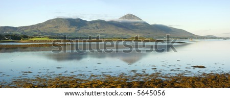 Early morning light of a September dawn strikes the misty slopes of Croagh Patrick, Co Mayo, Ireland and illuminates the little church at the summit, goal of an annual pilgrimage by the faithful.