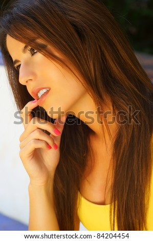 Portrait of beautiful young woman thinking with her in finger in her mouth