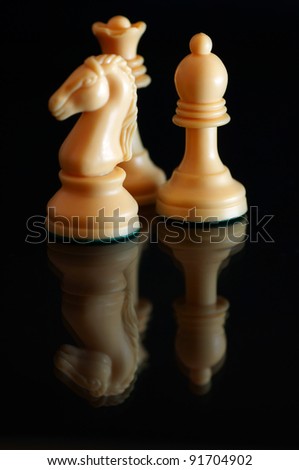 three chess pieces on black background