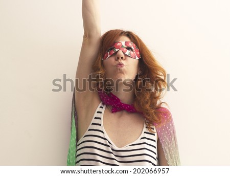 Superhero girl wearing mask with strawberries, pretending to be flying up