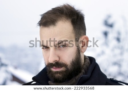 Portrait of a young man in the winter raising an eyebrow