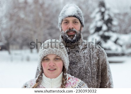 Cute hipster couple covered in snow, enjoying winter vacation