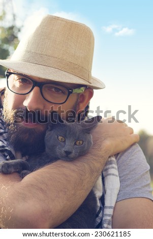 Happy hipster hugging his Russian Blue cat