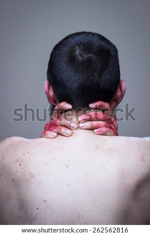 Naked man with his back turned, red painted hands on his neck