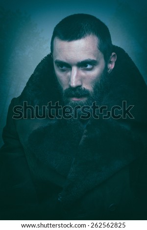 Portrait of an elegant bearded man in a fur coat. Very fashionable.