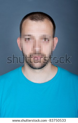 Photo of a young man, with hidden face via pixelation method. Large square pixels viewed at 100%. Identity concept.