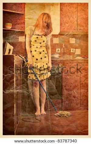 Vintage photo of a housewife, with iron, vacuum cleaner, and cleaning broom standing in the kitchen.