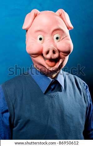 Close up portrait of a man wearing a pig mask. Both funny and spooky.