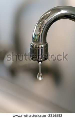 a water tap dripping a few drops of water