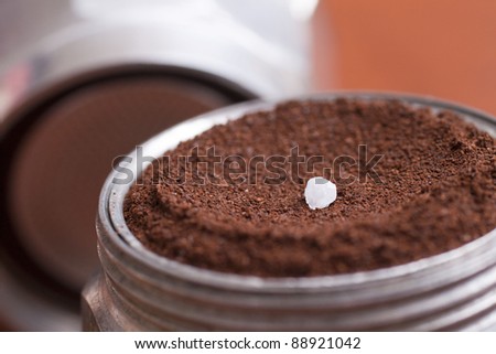 The image is an espresso coffee maker with a small grain of salt to ground coffee put together. The result is a coffee with a special flavor.