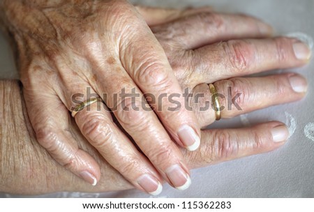 Senior wife touching the hand of her old husband, only hands