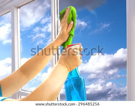 Person is cleaning a window with spray